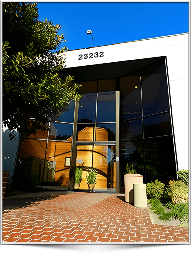 A building with a large glass door and brick walkway.